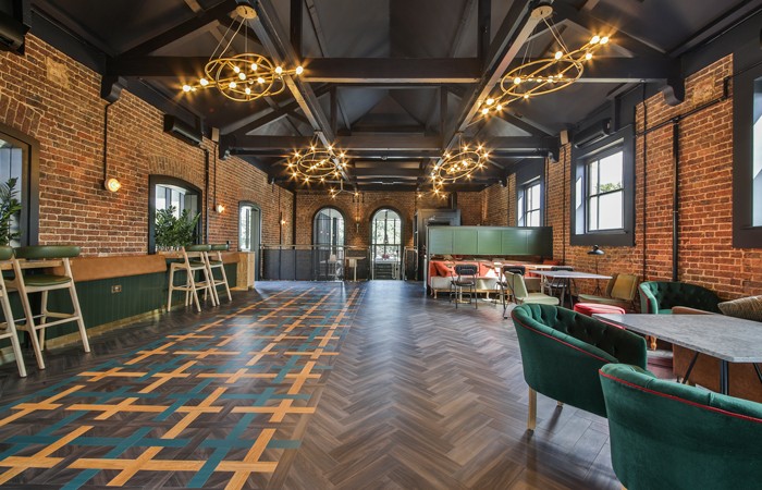 Design-Insider--floor-lighting-includes-six-eye-catching-chandeliers-beneath-exposed-ceiling-trusses